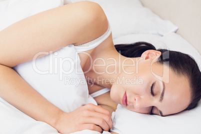 Beautiful brunette lying on her bed asleep