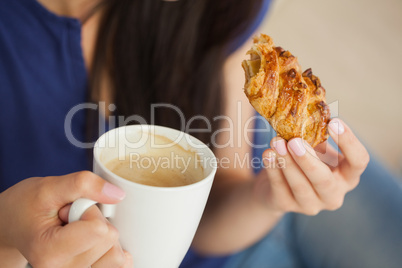 Woman having a pastry with a cup of coffee