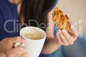 Woman having a pastry with a cup of coffee