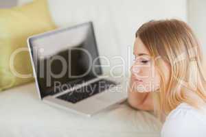 Thoughtful woman sitting on floor in front of laptop