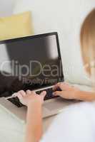 Blonde woman typing on laptop