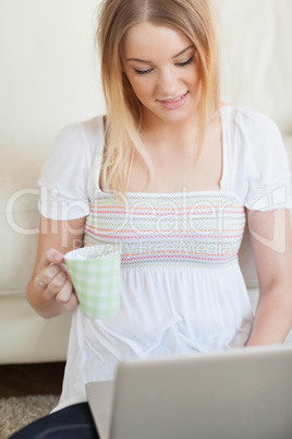 Woman sitting on floor using laptop