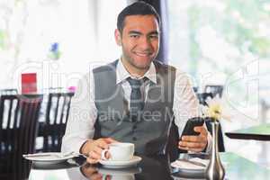 Businessman in a restaurant holding phone