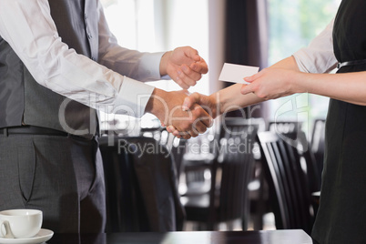 Busines people shaking hands after meeting and changing cards
