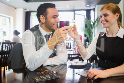 Happy business partners clinking wine glasses