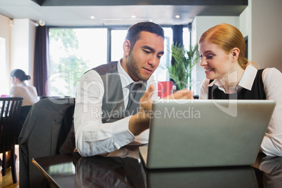 Two business people in a restaurant working together