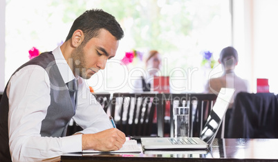 Concentrated businessman writing something