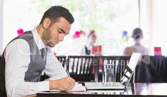 Concentrated businessman writing something