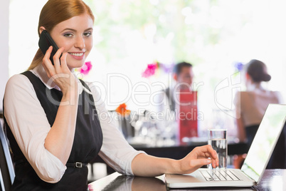 Businesswoman calling on phone and looking at camera