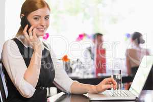 Businesswoman calling on phone and looking at camera