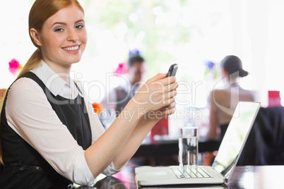 Happy businesswoman sending a text