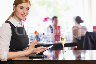 Businesswoman using tablet and looking at camera