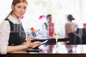 Businesswoman using tablet and looking at camera