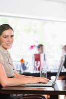 Happy businesswoman typing on laptop