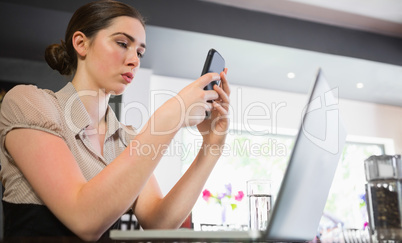 Concentrated businesswoman texting on phone