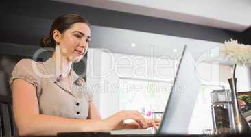 Happy businesswoman working on her laptop