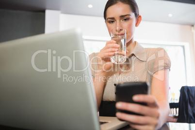 Businesswoman using phone in a cafe