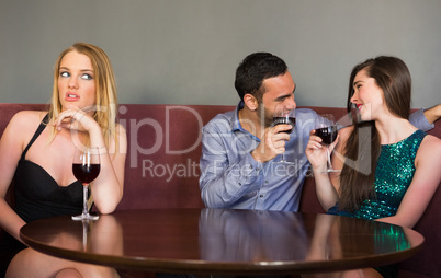 Blonde woman feeling lonely as two people are flirting beside he
