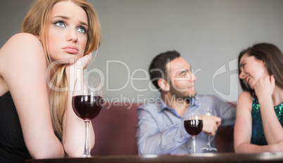 Blonde woman feeling jealous of couple flirting beside her