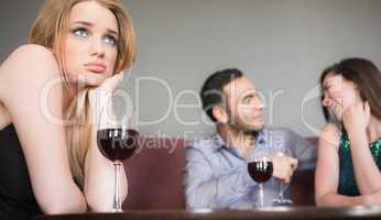 Blonde woman feeling jealous of couple flirting beside her