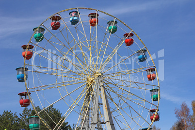 Atraktsion colorful ferris wheel against the blue sky