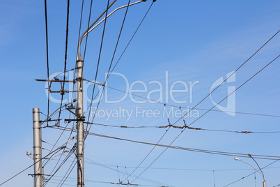 Railroad railway catenary lines against clear blue sky.