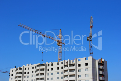construction site with two cranes against the sky