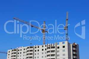 construction site with two cranes against the sky