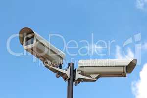 two security cameras against blue sky