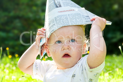 Baby with Paper on the summer meadow