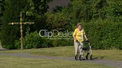 retiree pensioner walk with rollator in park 11074