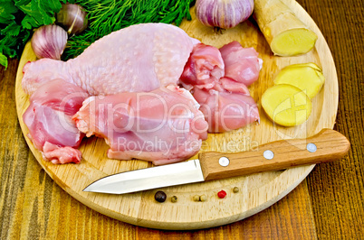 chicken leg cut on a wooden board with a knife