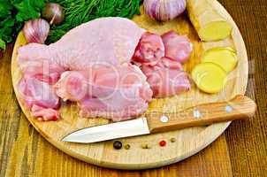 chicken leg cut on a wooden board with a knife