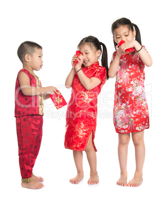 Asian children peeking into red packet
