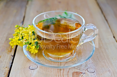 herbal tea from tutsan in a glass cup on a board