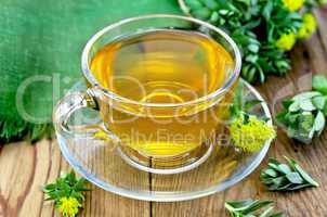herbal tea in a glass cup with rhodiola rosea on the board