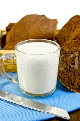 milk in a glass goblet with rye bread