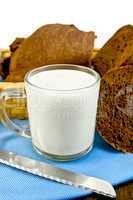 milk in a glass goblet with rye bread