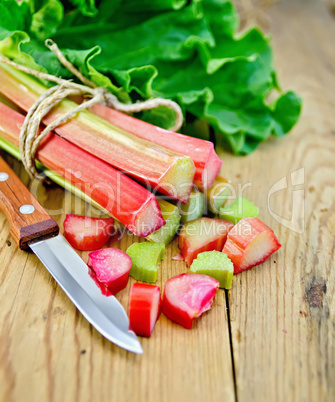 rhubarb cut with a knife on a wooden board