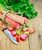 rhubarb cut with a knife on a wooden board