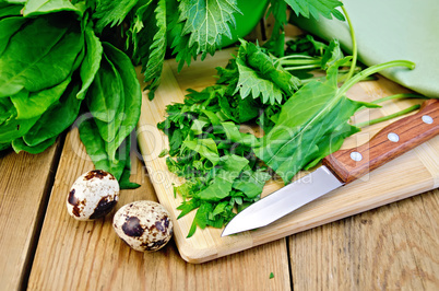 sorrel and nettles chopped on the board with quail eggs