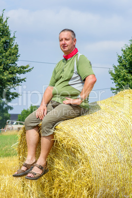 Farmer sitting on straw bales