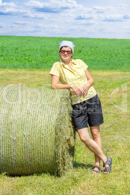 Farmer standing next to hay