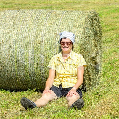 Farmer sitting in front of hay bales