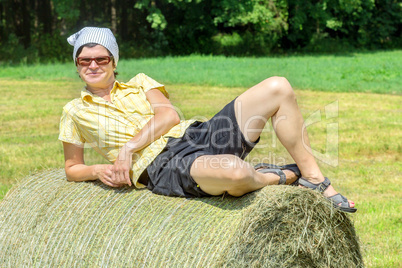 Peasant woman sitting on the hay bale