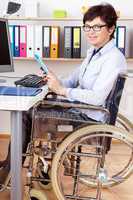 Disabled woman in wheelchair at desk