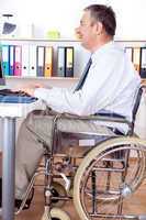 Man sitting in a wheelchair at the desk