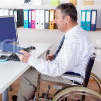 Man sitting in a wheelchair at the desk