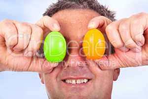 Man holding Easter eggs in front of the eyes