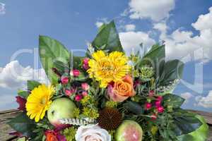 Bouquet with autumn decoration wooden table and blue sky